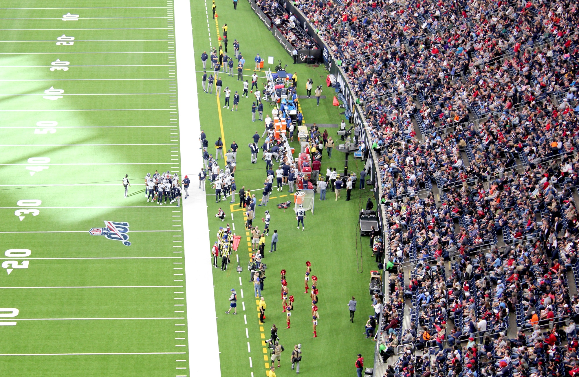 An audience of sports fans watching an NFL football game in a stadium